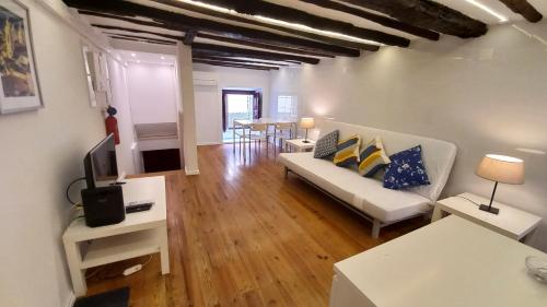 a living room with a white couch and a tv at Alfama Home in Lisbon