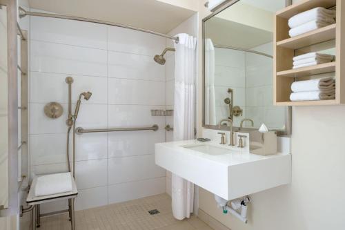 a white bathroom with a sink and a shower at Chicago Marriott Downtown Magnificent Mile in Chicago