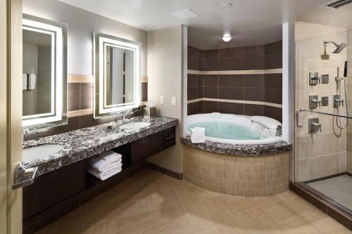 een badkamer met een bad, 2 wastafels en een douche bij South Sioux City Marriott Riverfront in South Sioux City