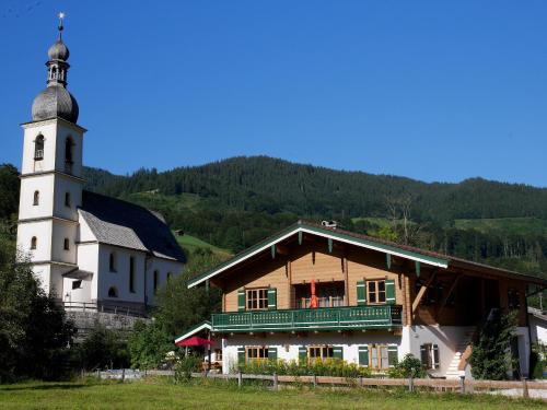a building with a clock tower next to a church at Berg-Loft Ramsau in Ramsau