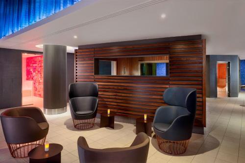 a waiting room with chairs and tables in a building at Sheraton Grand Hotel & Spa in Edinburgh