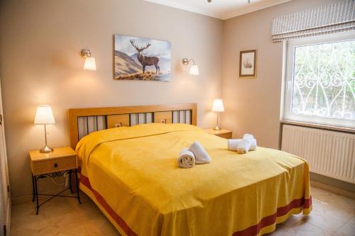 カルヴォエイロにあるVivenda Madrugadaのベッドルーム1室(黄色いベッド1台、タオル付)