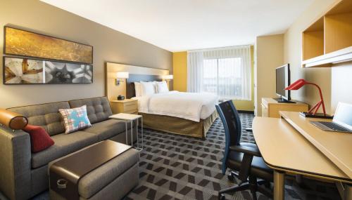 a hotel room with a bed and a couch at TownePlace Suites by Marriott Red Deer in Red Deer