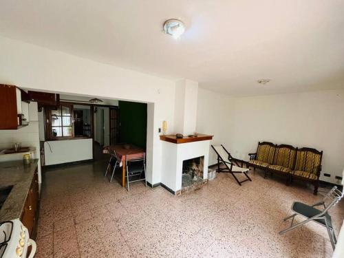 cocina y sala de estar con mesa y sillas. en Casa Itu. en Gualeguaychú