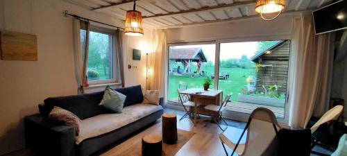 a living room with a couch and a large window at Apartamenty na wsi Horses&Relax in Młynary
