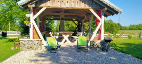 a gazebo with chairs and a table and a grill at Apartamenty na wsi Horses&Relax in Młynary