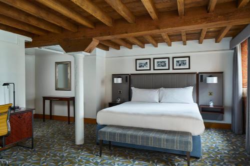 a bedroom with a large bed and a wooden ceiling at Manchester Marriott Victoria & Albert Hotel in Manchester