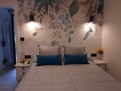 a large bed with blue pillows in a bedroom at Precioso Apartamento de 1 Habitación in O Barco de Valdeorras