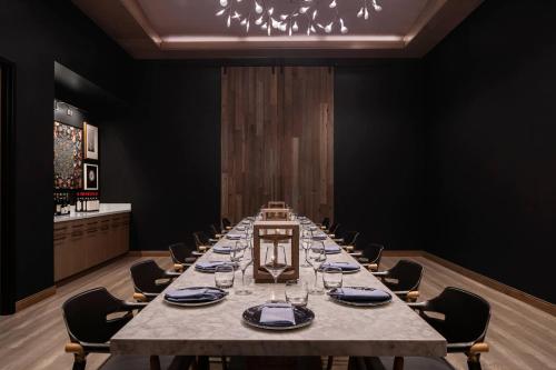 a long table in a room with chairs and a chandelier at Renaissance Milwaukee West Hotel in Wauwatosa