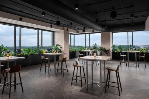 a restaurant with tables and chairs and windows at Renaissance Milwaukee West Hotel in Wauwatosa