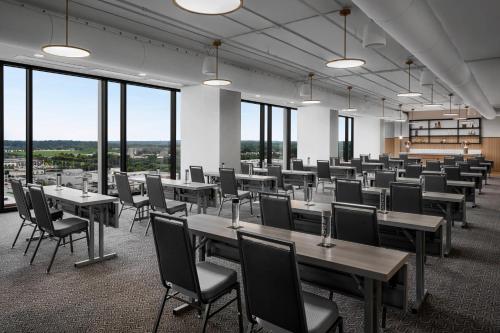 a large room with tables and chairs and windows at Renaissance Milwaukee West Hotel in Wauwatosa