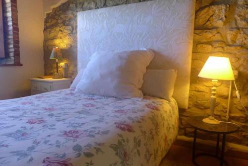 ein Schlafzimmer mit einem Bett und einer Steinwand in der Unterkunft Casa Rural Nel NRGA002R in Bojes