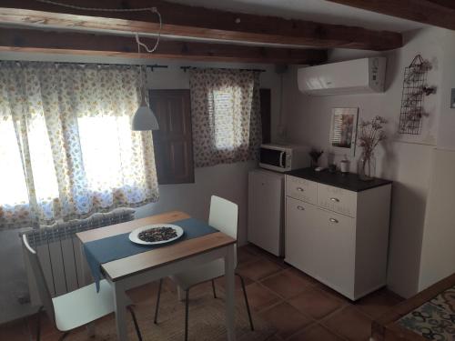Casa rural Lo Regolfo في La Codoñera: مطبخ وغرفة طعام مع طاولة وطاولة وكراسي