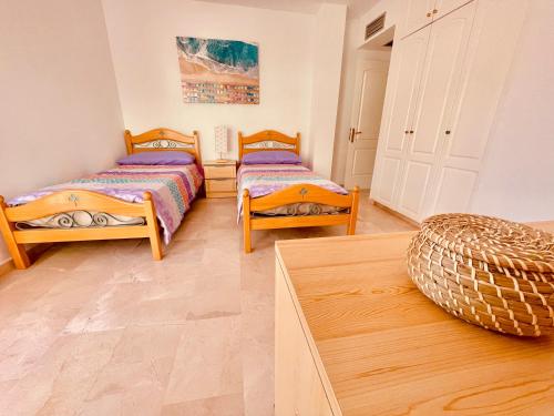een kamer met 2 bedden en een tafel bij Playa De Mogan Miramar in Puerto de Mogán
