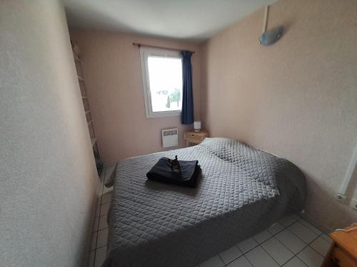 une petite chambre avec un lit et une fenêtre dans l'établissement Sol-y-Days Elysée, Appartement 2 pièces proche des quais du Port de plaisance et du lac de Salonique, avec parking, au Grau-du-Roi