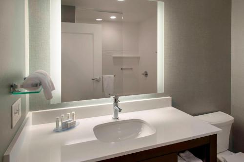 a bathroom with a sink and a mirror and a toilet at Residence Inn by Marriott Boston Bridgewater in Bridgewater