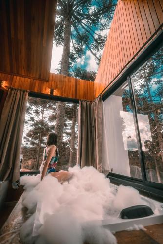 a woman is sitting on a bed of clouds at Morada Reino Encantado in São Joaquim