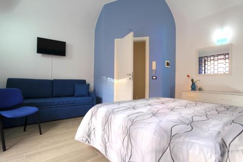 a bedroom with a bed and a blue couch at B&B La Grande Mela in Santo Stefano di Camastra