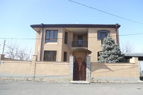 a house with a brown door and a tree at General guesthouse in Yerevan