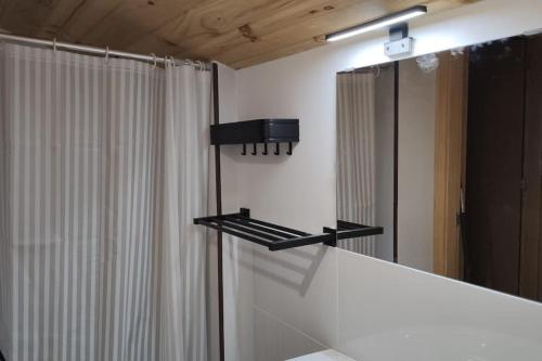 Baño con 2 estanterías en la pared y espejo en CASITA INDEPENDIENTE EN SUANCES Parking - Wifi - Jardín, en Cortiguera