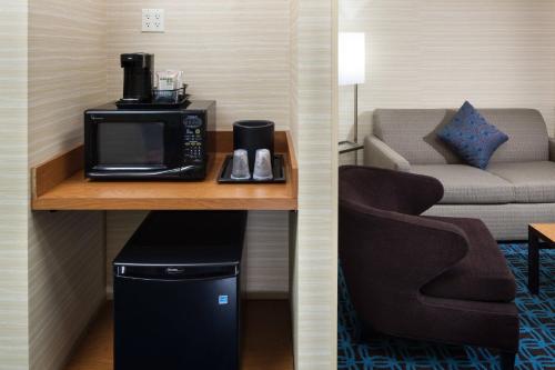 a room with a microwave on a table with a couch at Fairfield Inn and Suites Phoenix Chandler Fashion Center in Chandler