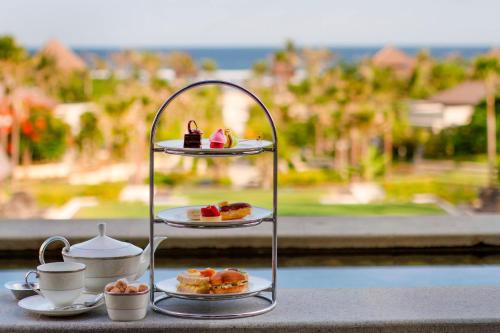 a tray of pastries and tea cups on a counter at The Ritz-Carlton Bali in Nusa Dua