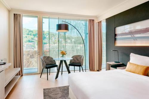 una camera d'albergo con letto, tavolo e sedie di Lyon Marriott Hotel Cité Internationale a Lione