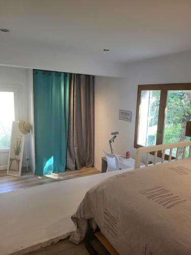 a bedroom with a bed with a blue curtain at Bas de villa proche Ajaccio in Bastelicaccia