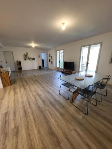 an empty living room with a table and chairs at Nouveau bas de villa, confort et détente in Bastelicaccia