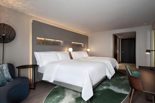a hotel room with two beds and a chair at The Westin London City in London