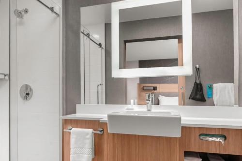 y baño con lavabo blanco y espejo. en SpringHill Suites by Marriott Raleigh Apex en Apex