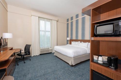 Fairfield Inn & Suites by Marriott Indianapolis Carmel في كارميل: غرفه فندقيه سرير وتلفزيون