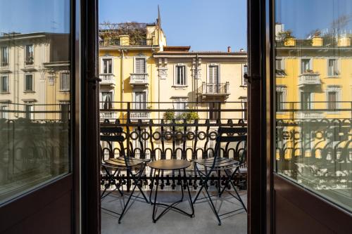 Habitación con vistas a un balcón con mesa y sillas. en Hotel Panizza, en Milán