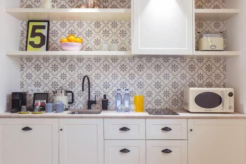 a kitchen with white cabinets and a microwave at Samaritana Suites in Palma de Mallorca