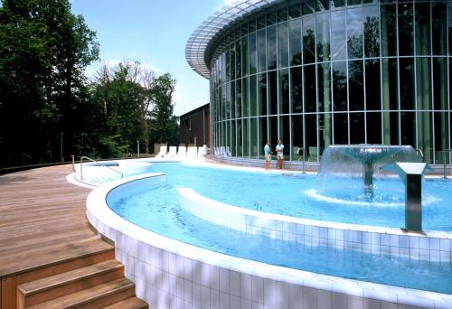 a swimming pool with a fountain in front of a building at Luxury Spa Hotel - Francofolies in Spa