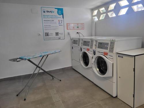 a laundry room with a washing machine and a table at Camping Costa Blanca in El Campello