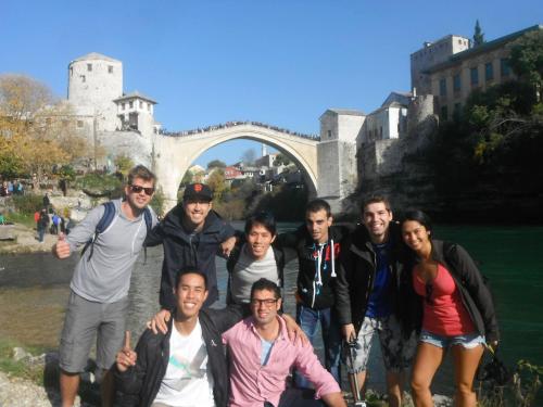 a group of people posing in front of a bridge at Hostel Miran Mostar in Mostar
