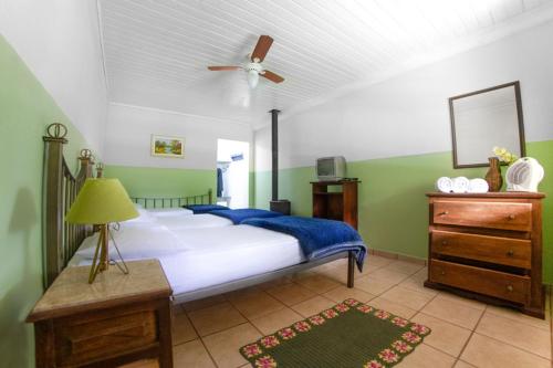 um quarto com uma cama e uma ventoinha de tecto em Pousada Águas do Vale em Atibaia