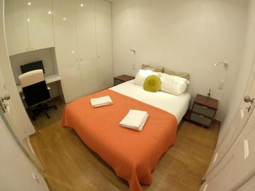 a bedroom with a large bed with an orange blanket at Lisbon, renewed T1 apartment with pateo near Martires da Patria in Lisbon