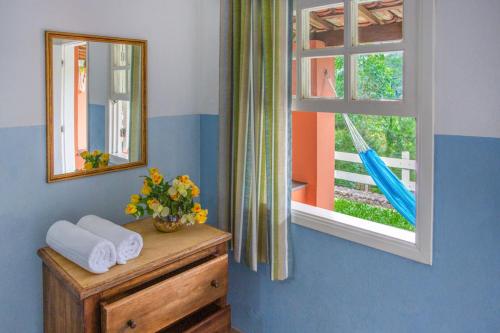 baño con espejo y tocador con toallas en Pousada Águas do Vale en Atibaia