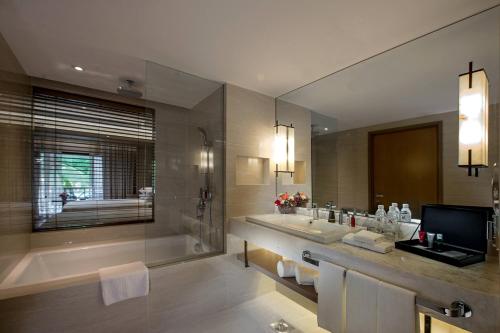 een grote badkamer met 2 wastafels, een bad en een tubermott bij Miri Marriott Resort & Spa in Miri