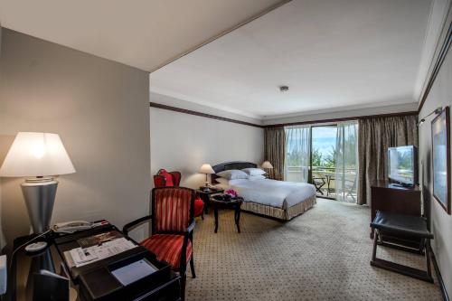 a hotel room with a bed and a desk and a television at Miri Marriott Resort & Spa in Miri