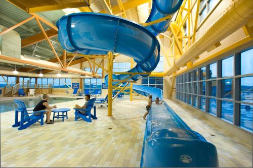 a water slide in a building with two people sitting at Delta Hotels by Marriott Beausejour in Moncton