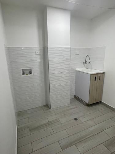 Baño blanco con lavabo y espejo en Hermoso apartamento moderno, excelente ubicación cerca al centro histórico, en Bogotá