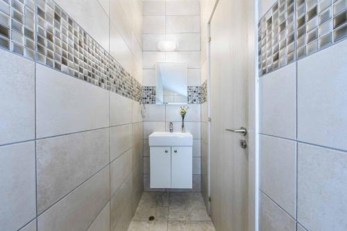 ein weißes Badezimmer mit einem Waschbecken und einem Spiegel in der Unterkunft Villa Alasia in Paralimni
