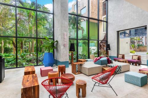 a living room with furniture and large windows at Aloft Tulum in Tulum