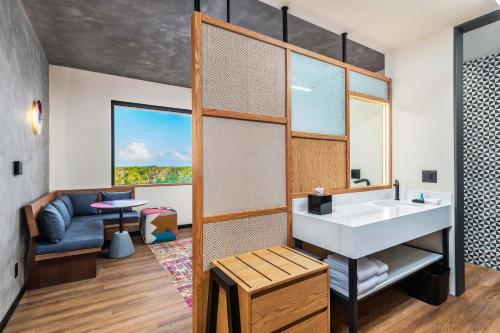a bathroom with a sink and a couch at Aloft Tulum in Tulum