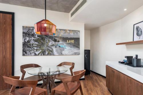 a kitchen and dining room with a glass table and chairs at Aloft Tulum in Tulum