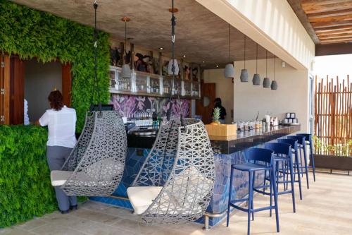a woman standing at a bar in a restaurant at Aloft Tulum in Tulum