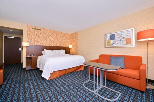 a hotel room with a bed and a couch at Fairfield Inn and Suites by Marriott Rochester West/Greece in Rochester